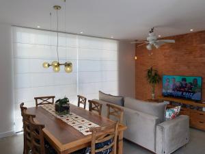 a dining room with a table and a couch at Casa de praia in Paraty
