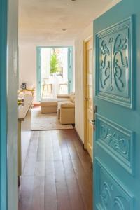 a hallway with a blue door and a living room at Best location - Luxury and charming loft in Panama City