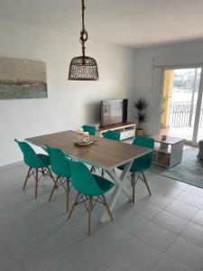 a dining room with a wooden table and green chairs at Aquamarine Sant Feliu en la playa con patio in Sant Feliu de Guixols