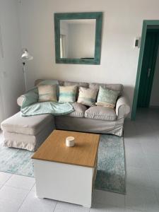 a living room with a couch and a mirror at Aquamarine Sant Feliu en la playa con patio in Sant Feliu de Guixols