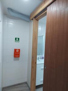 a bathroom with a toilet and a door with a sink at Casas da Tia Florinda - Casa Flor de Laranjeira in Faial da Terra