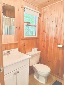 a bathroom with a toilet and a sink and a window at Muskoka Escape in Port Carling