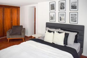 a bedroom with a bed and a chair and pictures on the wall at Amazing Loft with the Best view of Casco viejo! in Panama City