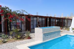 una casa con piscina e un edificio di HOTEL LUCERO PARACAS a Paracas