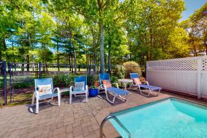 - un groupe de chaises assises à côté de la piscine dans l'établissement New Seabury Escape, à Mashpee