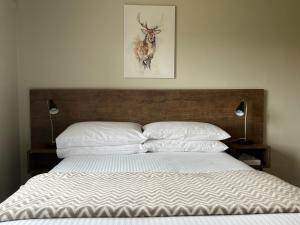 1 cama con 2 almohadas y una foto de un ciervo en Swagman Chalet, en Perisher Valley