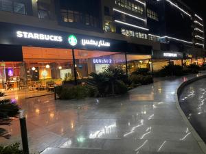 an empty sidewalk in front of a building at night at A Family Friendly Apartment in Cairo