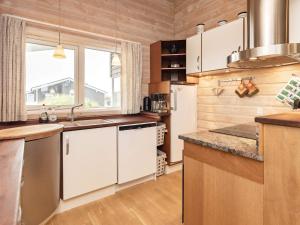 クリムトラにある10 person holiday home in Thistedの白いキャビネットと大きな窓付きのキッチン