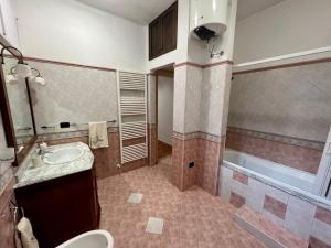 een badkamer met een wastafel, een toilet en een bad bij La Pietra Messapica in Manduria