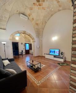 een woonkamer met een bank en een tv bij La Pietra Messapica in Manduria
