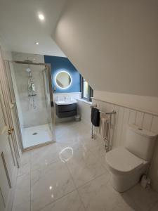 y baño con aseo, ducha y lavamanos. en Chic Classy & Cosy in Lough Erne 5* Resort en Ballycassidy