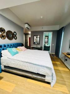 Our cozy and exclusive 2BR at Kemang Village في جاكرتا: غرفة نوم مع سرير كبير مع اللوح الأمامي الأزرق