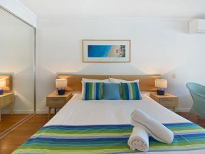 een slaapkamer met een groot bed en handdoeken bij Blue on Blue Studio Room 1222 in Nelly Bay