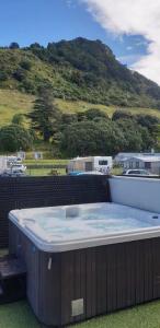 uma grande banheira de hidromassagem numa varanda com uma montanha em The Bay The Beach The Mount The Best em Mount Maunganui