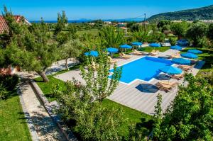 einen Luftblick auf ein Resort mit Pool und Sonnenschirmen in der Unterkunft Peristera in Kateliós