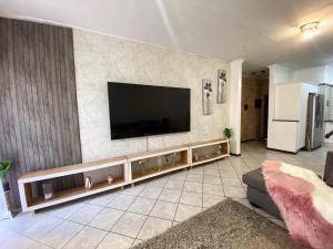 a living room with a flat screen tv on a wall at Siena Sun Apartment 4 in Midrand