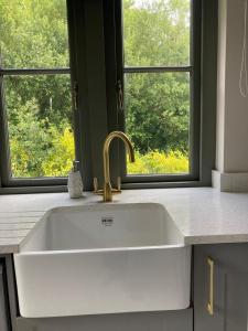 a white sink in a kitchen with a window at Chic Classy & Cosy in Lough Erne 5* Resort in Ballycassidy