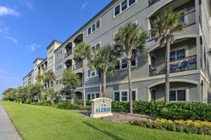 a large apartment building with a sign in front of it at Miramar Beach Condo with Pool - Walk to Beach! in Destin