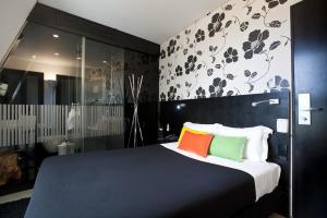 a bedroom with a large bed with colorful pillows at Funchal Design Hotel in Funchal