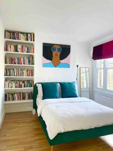 1 dormitorio con cama y estanterías con libros en Home in Chiswick Homefields, en Londres