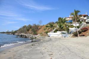 - une plage bordée de palmiers et de maisons dans l'établissement El Canto del Mar, à Santa Marta
