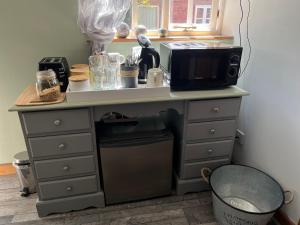 a kitchen counter with a microwave and a trash can at Pear Tree Cottage in Shrewsbury