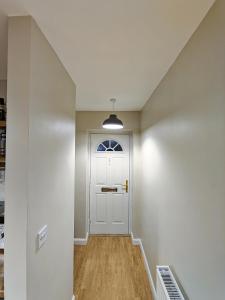 a hallway with a white door and a window at Joshua Court Single Room in Stoke on Trent