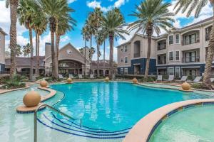 una piscina en una villa con palmeras en Beautiful spacious apartment !, en Webster