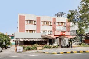 un edificio alto rojo al lado de una calle en SPOT ON 93332 Hotel Maharaja, en Mysore