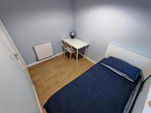 Cette petite chambre comprend un lit et une table. dans l'établissement Joshua Court Single Room, à Stoke-on-Trent