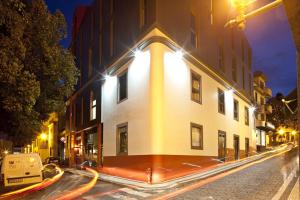 a building on a city street at night at Funchal Design Hotel in Funchal