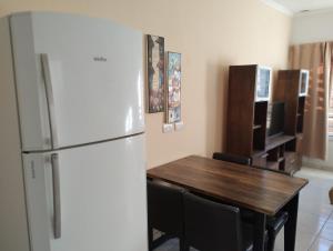 uma cozinha com um frigorífico e uma mesa com cadeiras em Depto Civora 2 em Villa Regina
