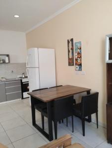 uma cozinha com uma mesa de madeira e um frigorífico em Depto Civora 2 em Villa Regina