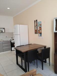 a kitchen with a wooden table and a refrigerator at Depto Civora 2 in Villa Regina