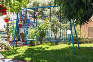 a playground in a yard with a swing at Olive tree villa in Ligia