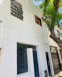 Biały dom z drzwiami i drzewem w obiekcie Mini house con sol y luz w BuenosAires