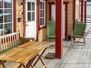 eine Veranda mit einem Holztisch und Stühlen auf einem Haus in der Unterkunft 5 person holiday home in TEGEFJ LL in Ängena