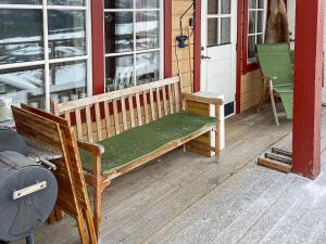 eine Holzbank auf der Veranda eines Hauses in der Unterkunft 5 person holiday home in TEGEFJ LL in Ängena