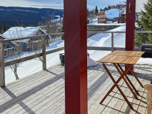 a wooden table on a deck with snow on the ground at 5 person holiday home in TEGEFJ LL in Ängena