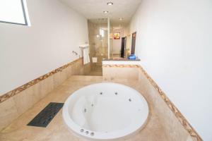 y baño con ducha y bañera blanca grande. en Quinta Las Acacias Hotel Boutique, en Guanajuato