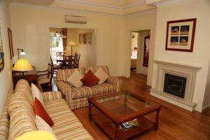 a living room with two couches and a fireplace at Vila Alba Resort in Carvoeiro
