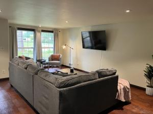 sala de estar con sofá grande y TV de pantalla plana en Forks Fir House en Forks