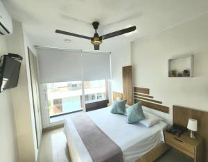 a bedroom with a bed with a ceiling fan at Loft 39 in Coveñas