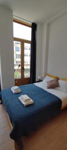 1 dormitorio con 2 camas y toallas. en Get Cozy, en Oporto