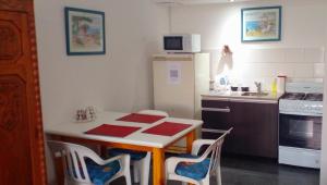 een keuken met een tafel en stoelen en een koelkast bij EXCELENTE UBICACIÓN in Concordia