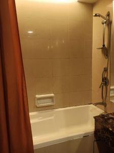 une salle de bain avec baignoire et douche dans l'établissement Vacation Stay at Resort Suites Bandar Sunway, à Kampong Penaga