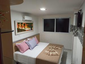 若昂佩索阿Manaira Flat的小卧室配有带粉色和灰色枕头的床 更多37张照片