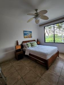 ein Schlafzimmer mit einem Bett und einem Deckenventilator in der Unterkunft Apartamentos Los Cabos Monterrico by l´Aurora Inn in Taxisco