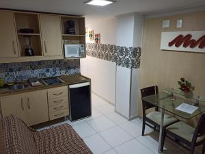 una pequeña cocina con mesa y encimera en Manaira Flat, en João Pessoa