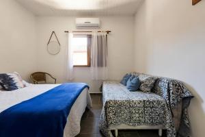 a bedroom with two beds and a couch and a window at FLAT EM JUQUEHY COM AR COND, PISCINA e CHURRASQUEIRA in São Sebastião +36 photos